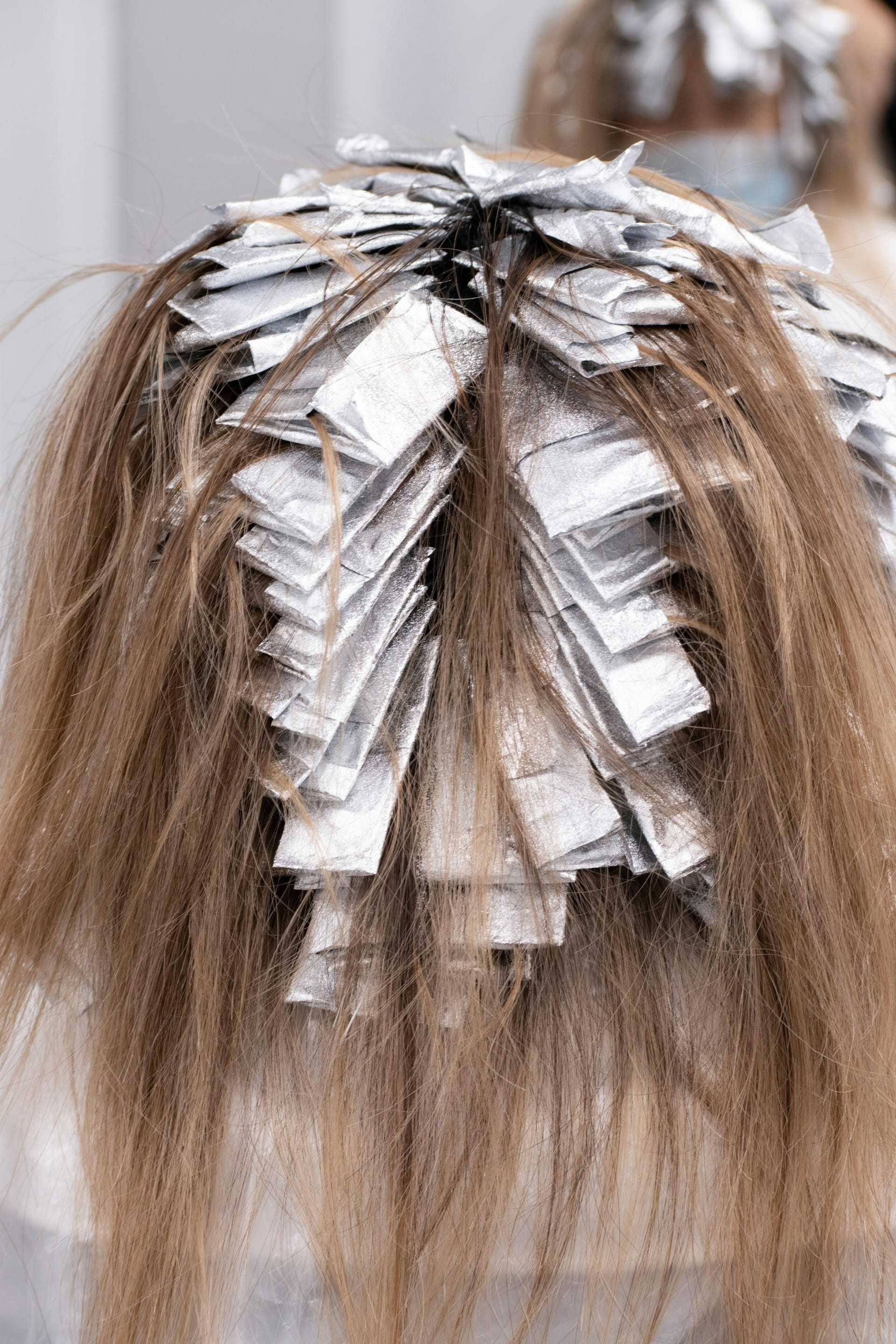 Hair receiving highlights with foil wraps during treatment process.