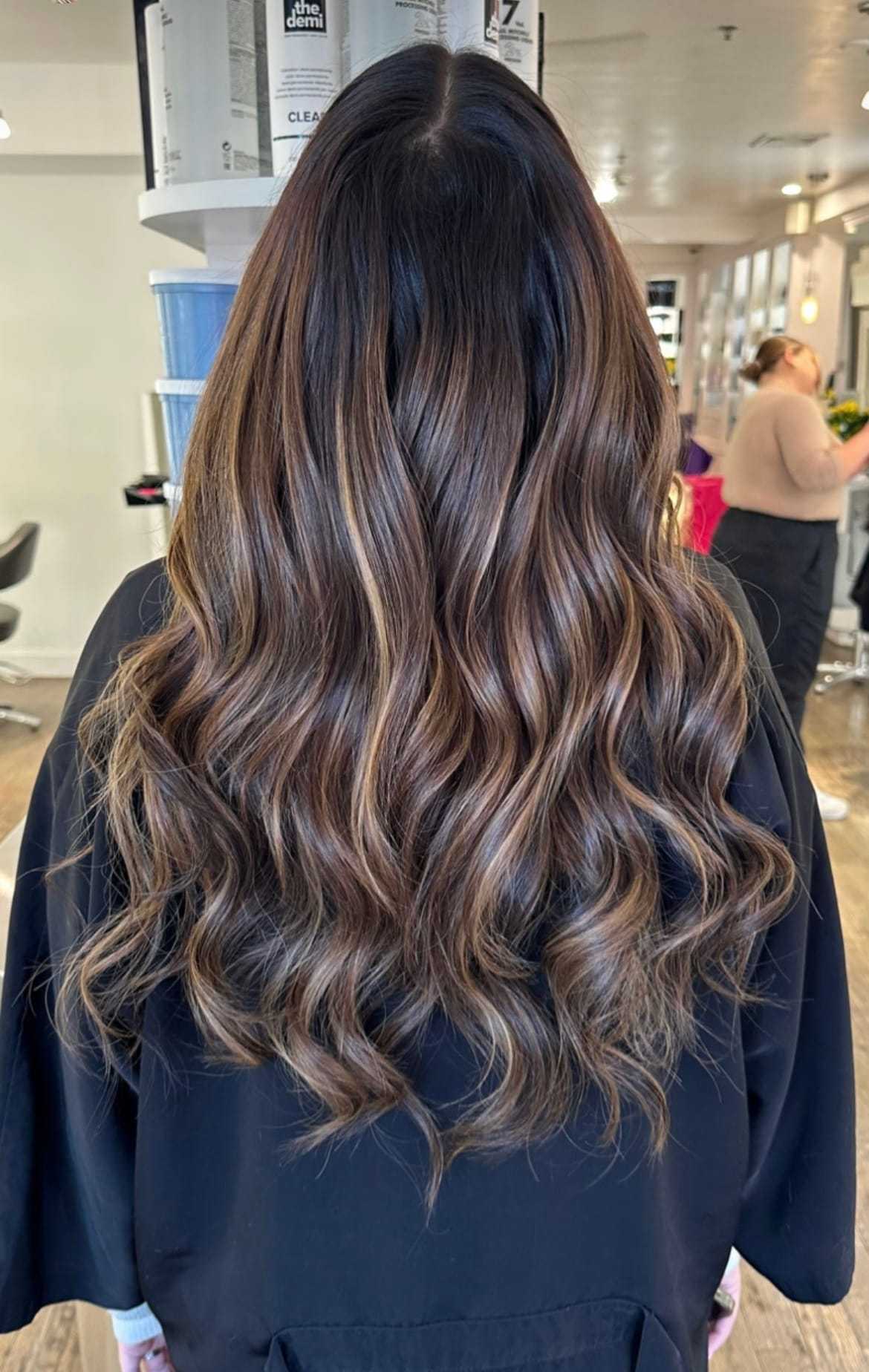 Wavy brown hair with highlights at a salon.